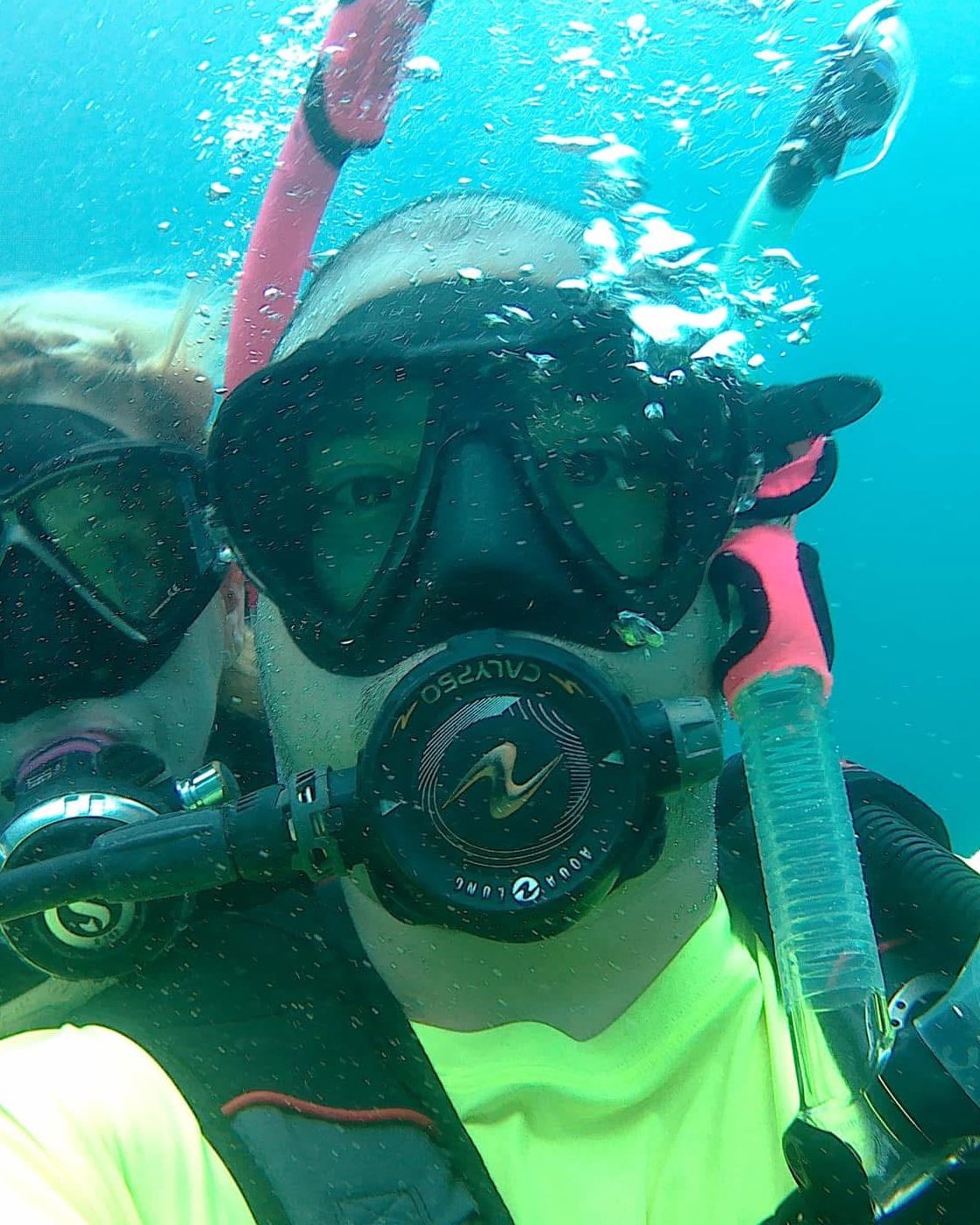Tiger underwater in dive gear with Shawn right behind him