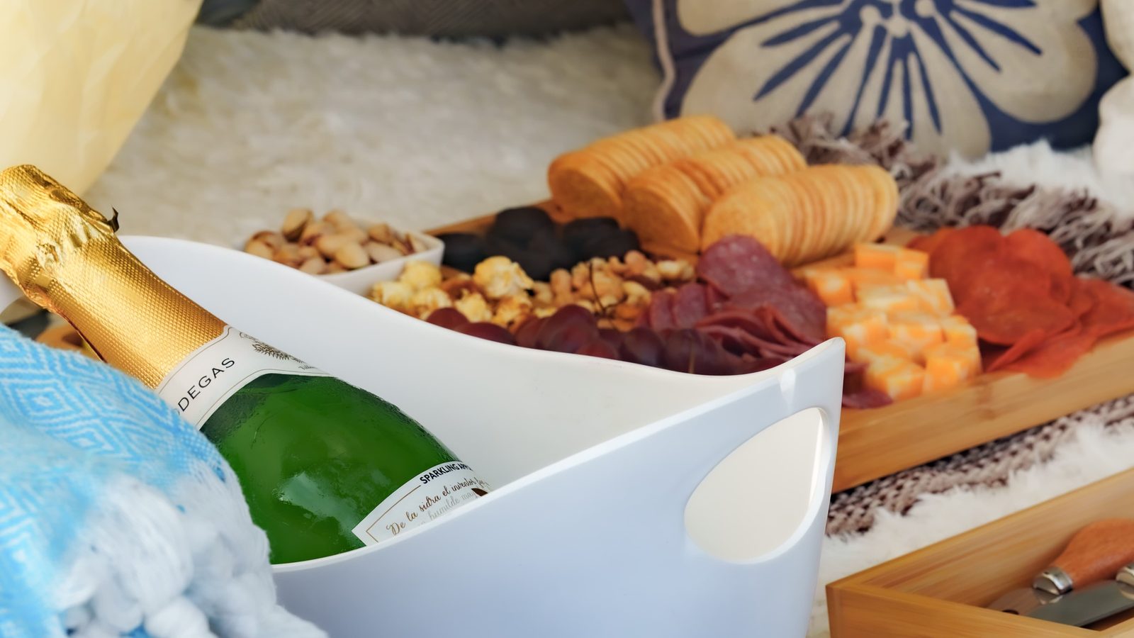 A charcuterie board and chilled bottle laid out inside the tent
